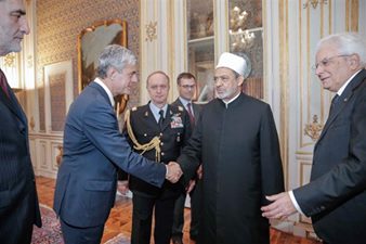 Image may contain: one or more people, people standing and suit